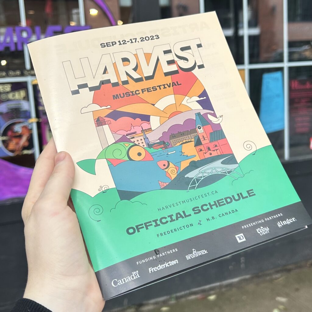 image of hand holding the 2023 Harvest Festival brochure
