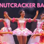 pink text "THE NUTCRACKER BALLET" on image of 7 ballerinas in pink tutus.