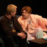 two people sat on a couch in conversation