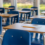 rows of empty classroom chairs and desks