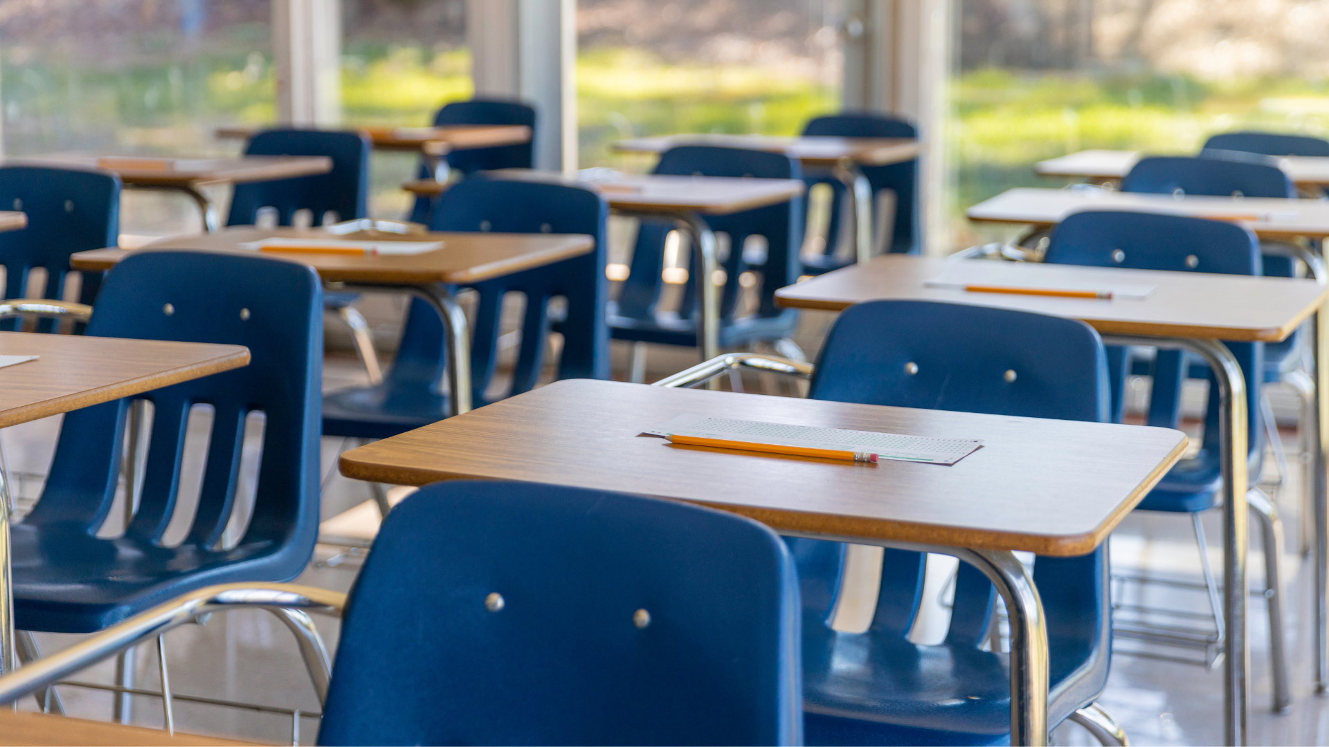 rows of empty classroom chairs and desks