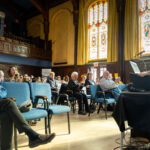 Jamie Kitts reading in front of a crowd of poetry weekend attendees in Memorial Hall.